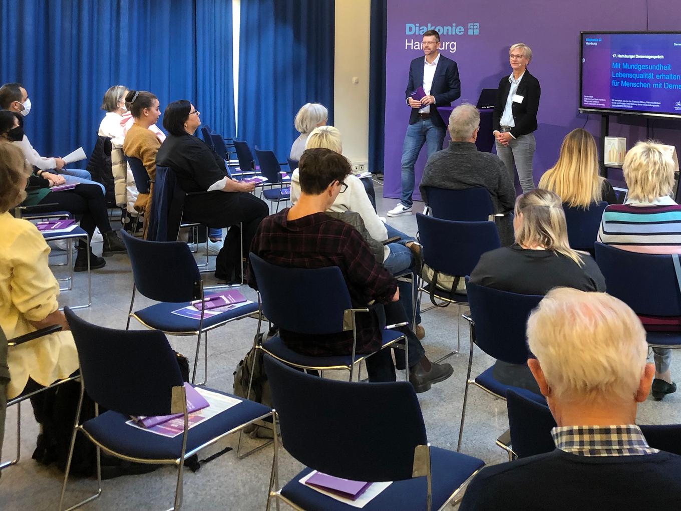 Mehrere Teilnehmende sitzen in einem Seminarraum bei der Veranstaltung zum Thema Mundgesundheit bei Demenz