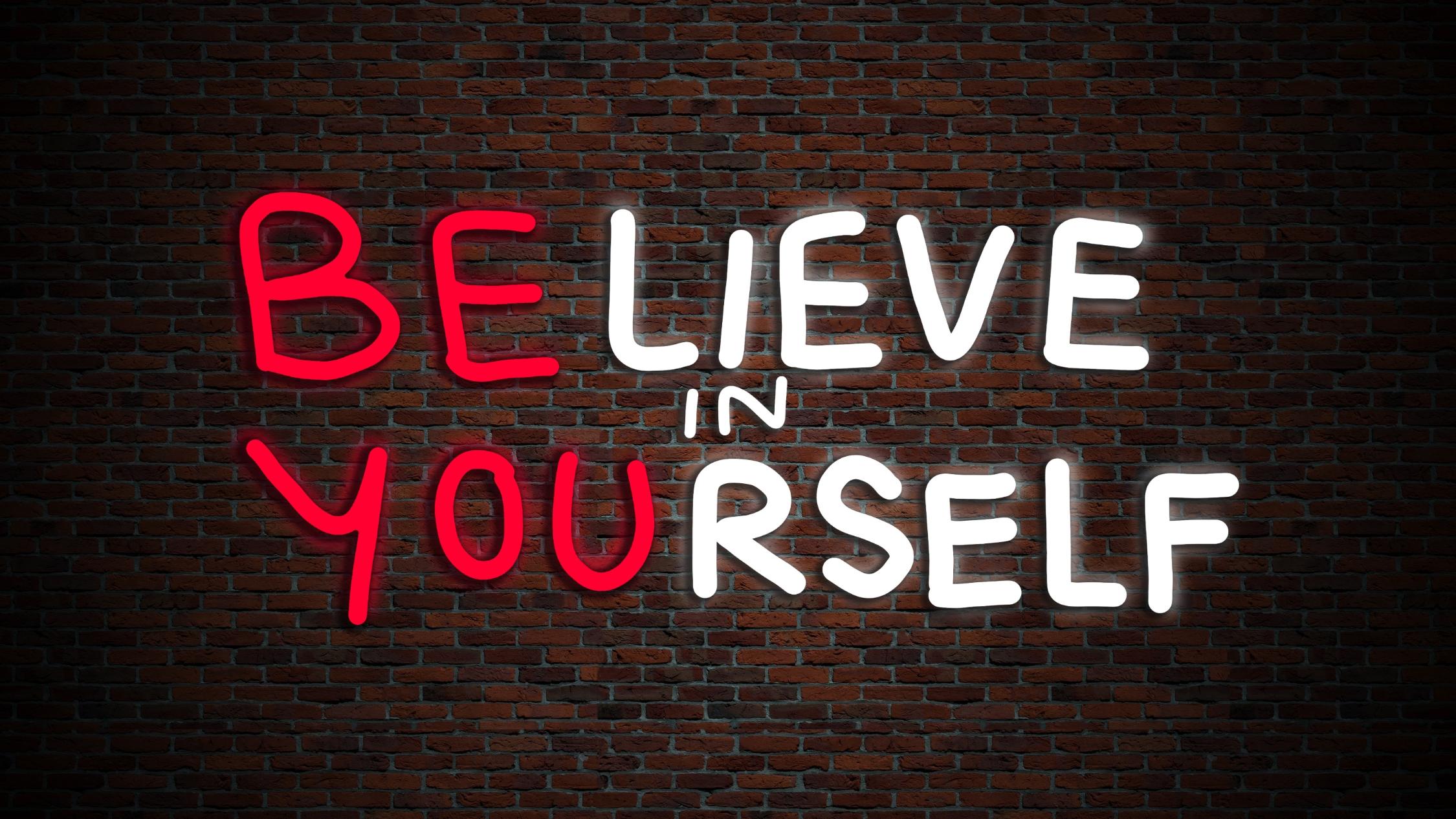 Leuchtschrift an einer Backsteinwand: believe in yourself