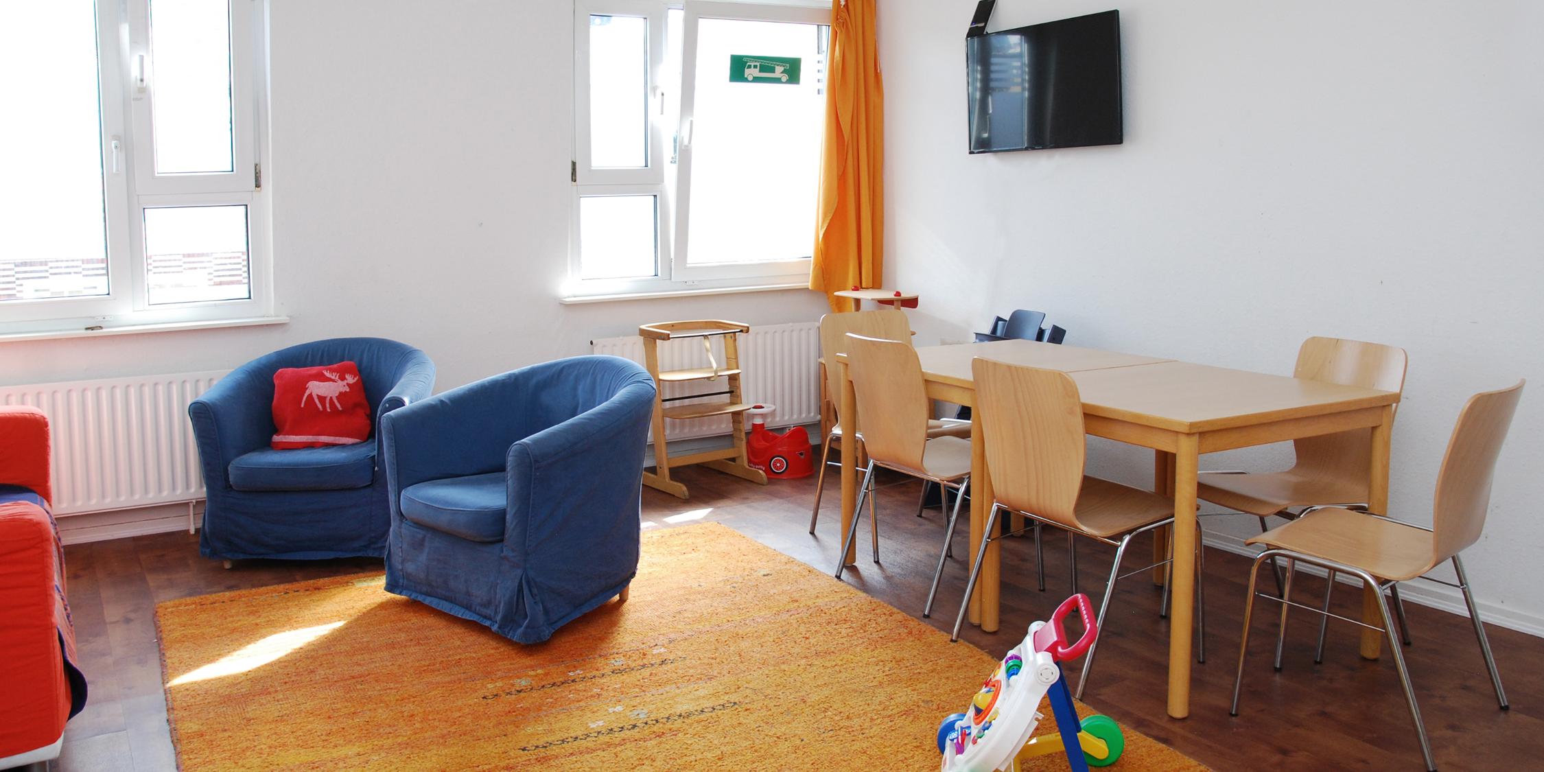 Kochbereich und Wohnbereich im Frauenhaus mit Esstisch und Spielzeug