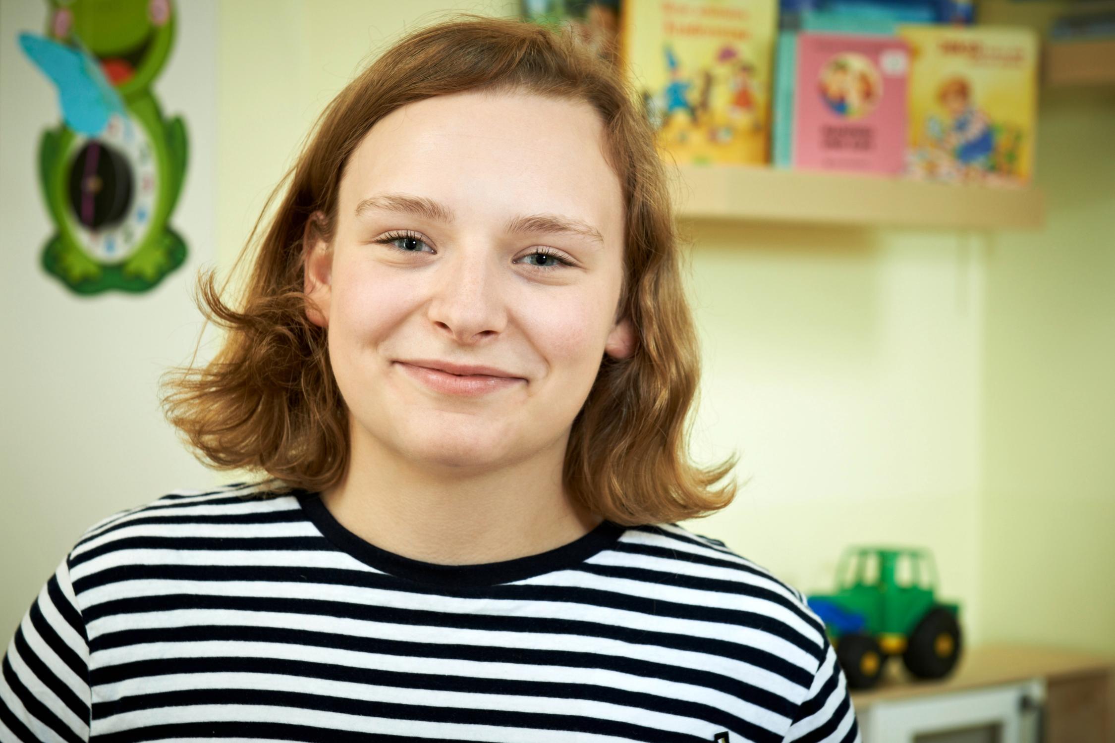 Eine junge Frau lächelt in die Kamera.