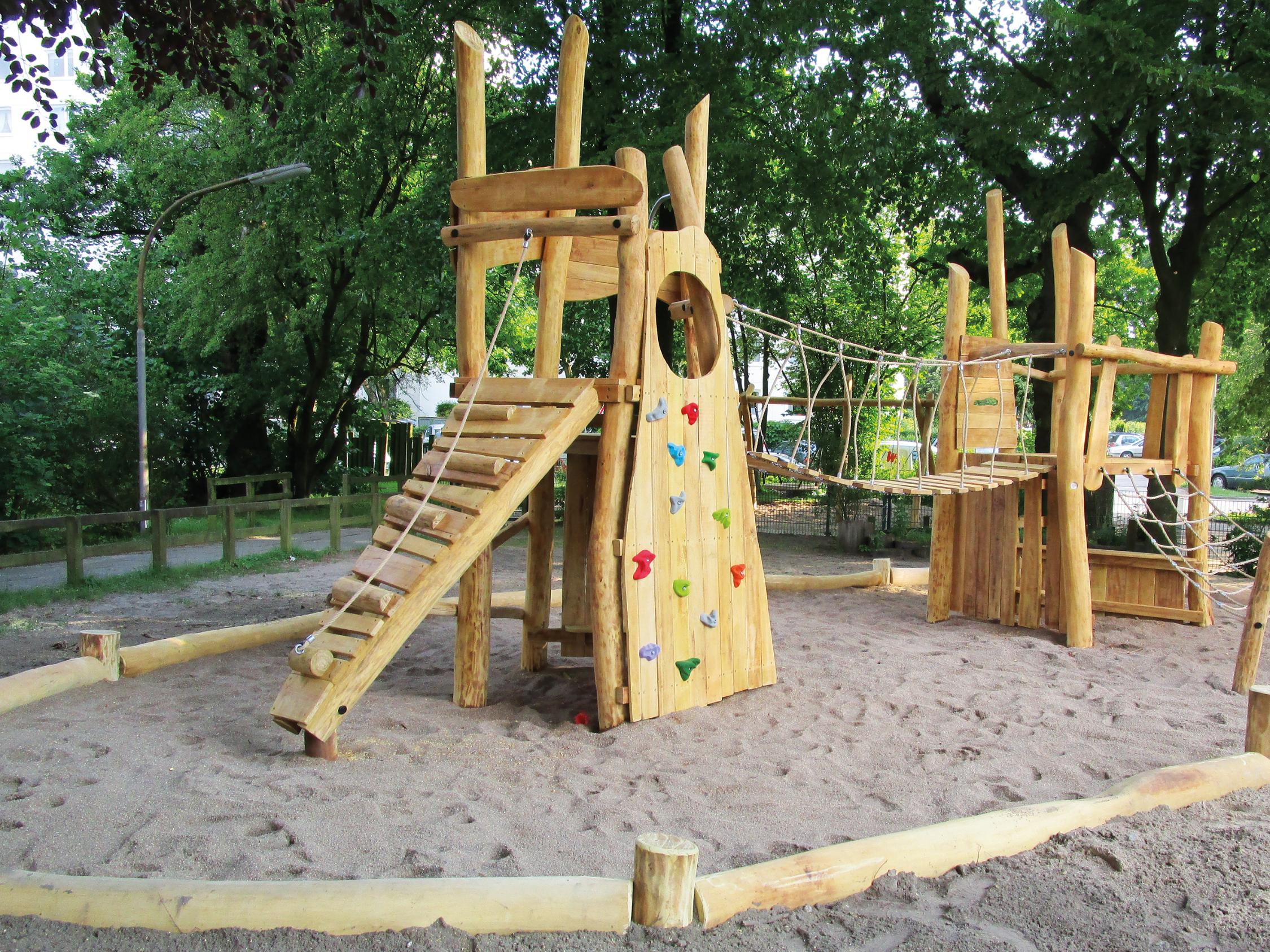 Ein Klettergerüst aus Holz in einem eingezäunten Park.