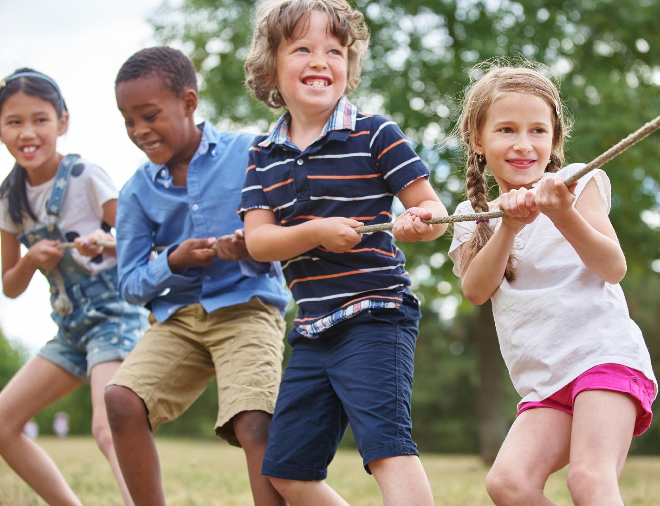 Vier Kinder ziehen gemeinsam an einem Seil.