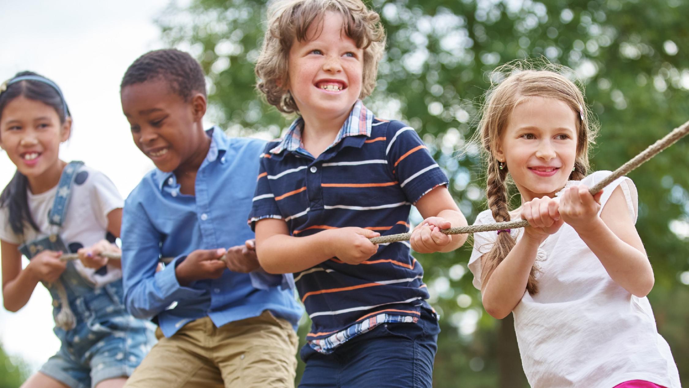 Vier Kinder ziehen gemeinsam an einem Seil.