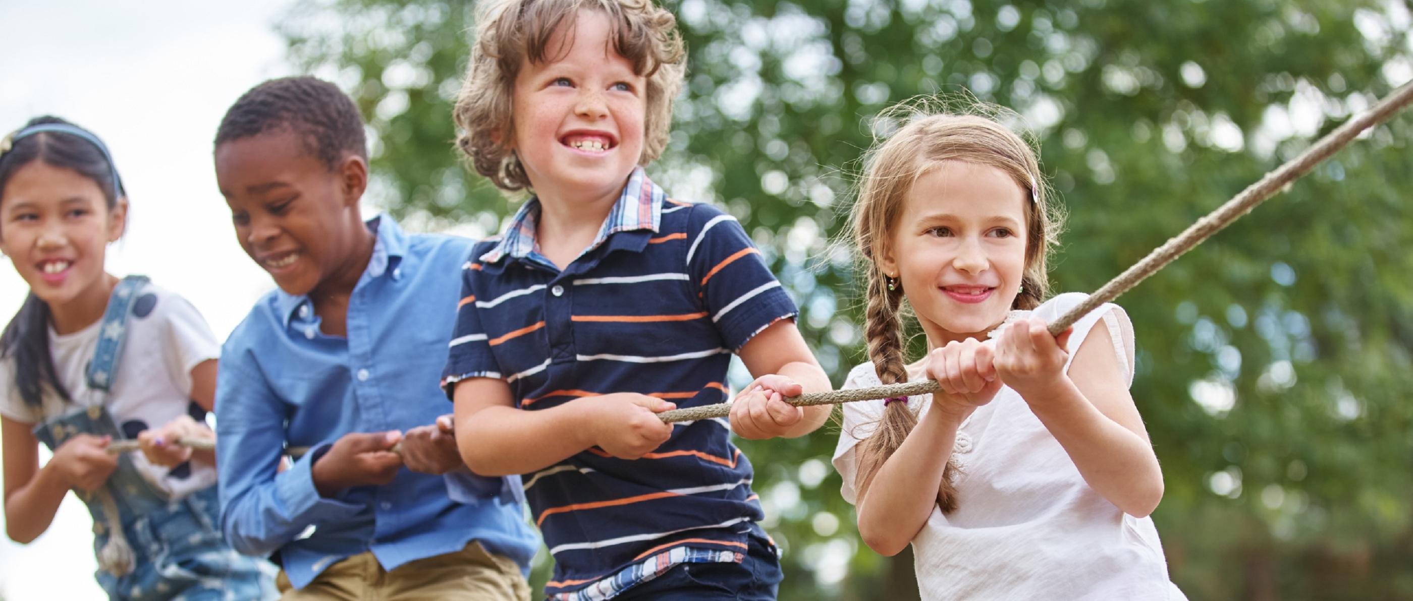 Vier Kinder ziehen gemeinsam an einem Seil.