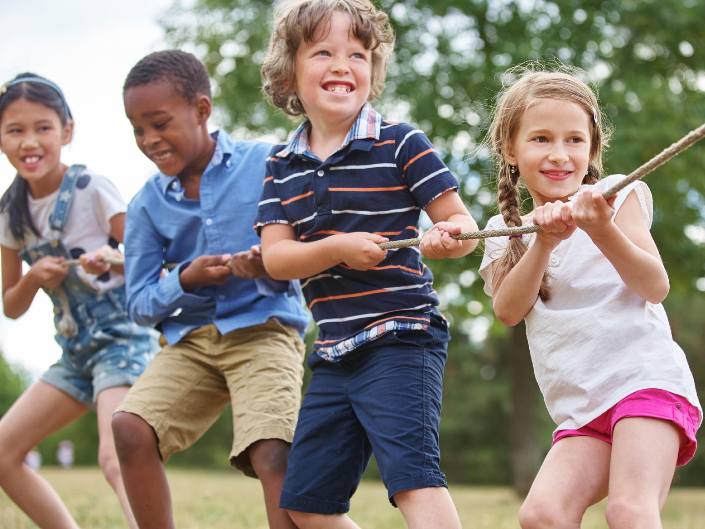 Vier Kinder ziehen gemeinsam an einem Seil.