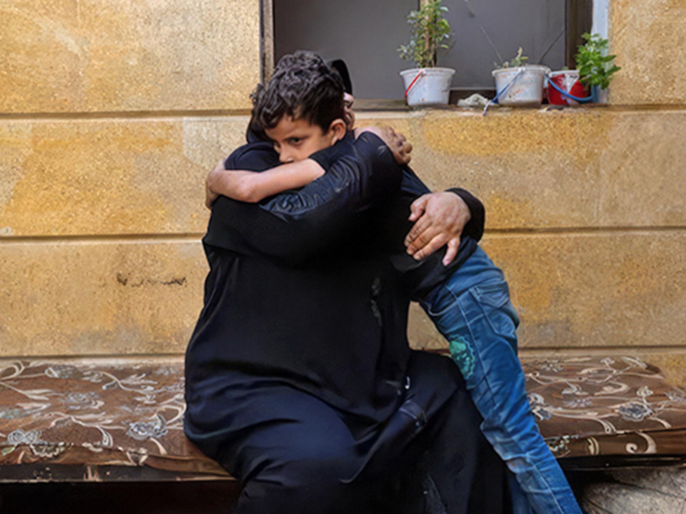 Eine Frau und ein Junge umarmen sich.