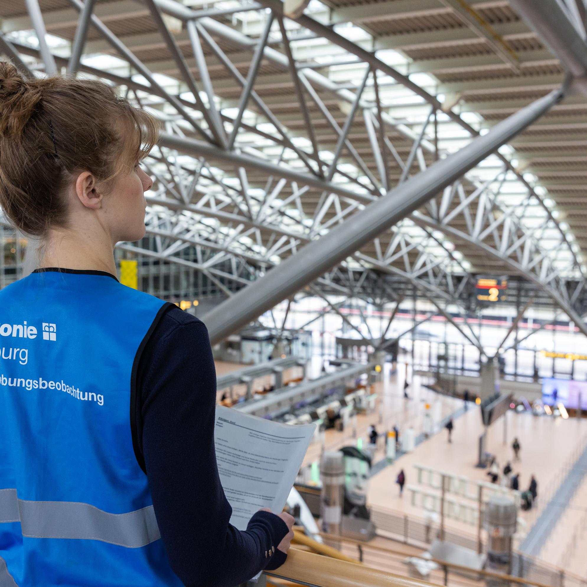 Ein Frau notiert und begleitet die Abschiebungen am Flughafen Hamburg