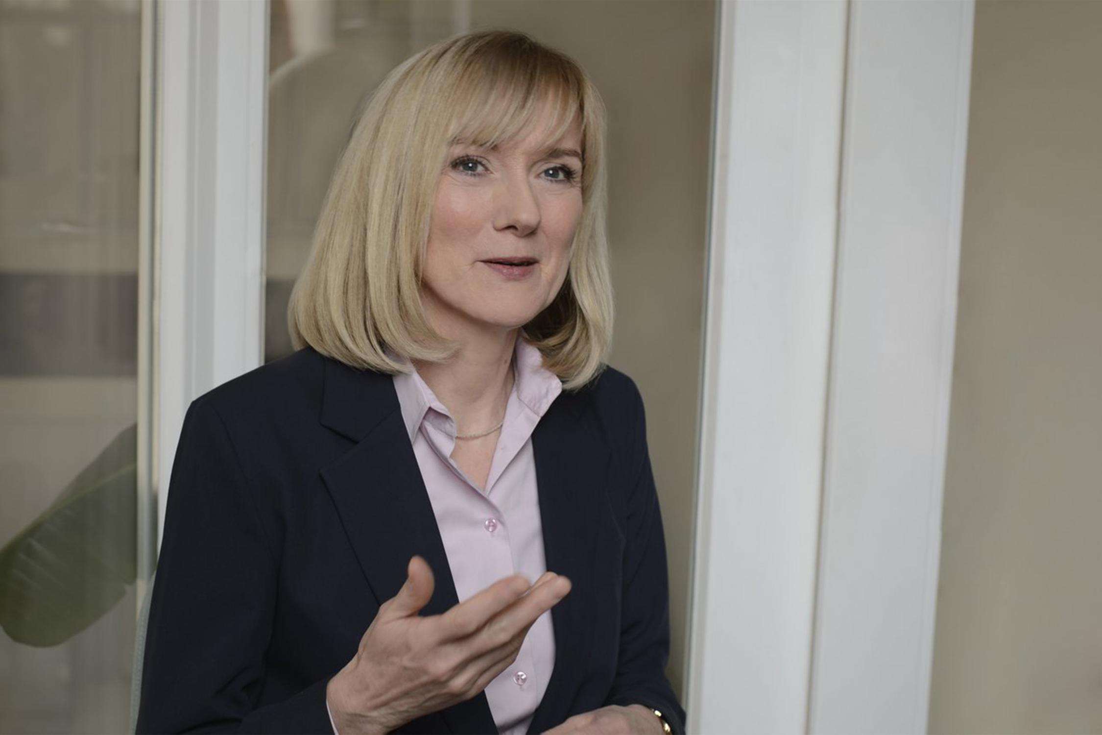 Eine Frau spricht in die Kamera und gestikuliert mit der rechten Hamd.