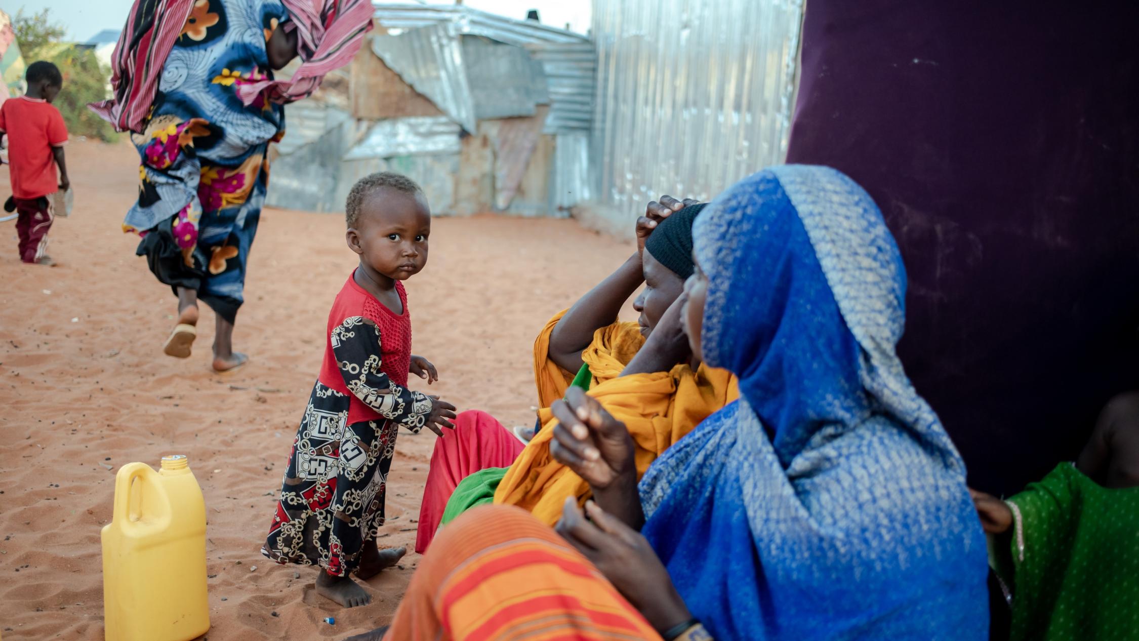 Eine Mutter sitzt mit ihrer Familie vor einer provisorischen Unterkunft in einer Siedlung für Dürreflüchtlinge in Galkayo. Als Reaktion auf die zunehmende Dürre und auf die wachsende Hungerkatastrophe in Somalia ist das oberste Ziel des Projekts der Diakonie Katastrophenhilfe, einen Beitrag zu einem verbesserten und sicheren Zugang zu Wasser und Hygiene, zur Ernährungssicherheit sowie zu anderen Grundbedarfen für besonders von der Dürre und vom Gewaltkonflikt betroffene Binnenvertriebene zu leisten.  Projektpartner: Zentrum für Frieden und Demokratie - CPD