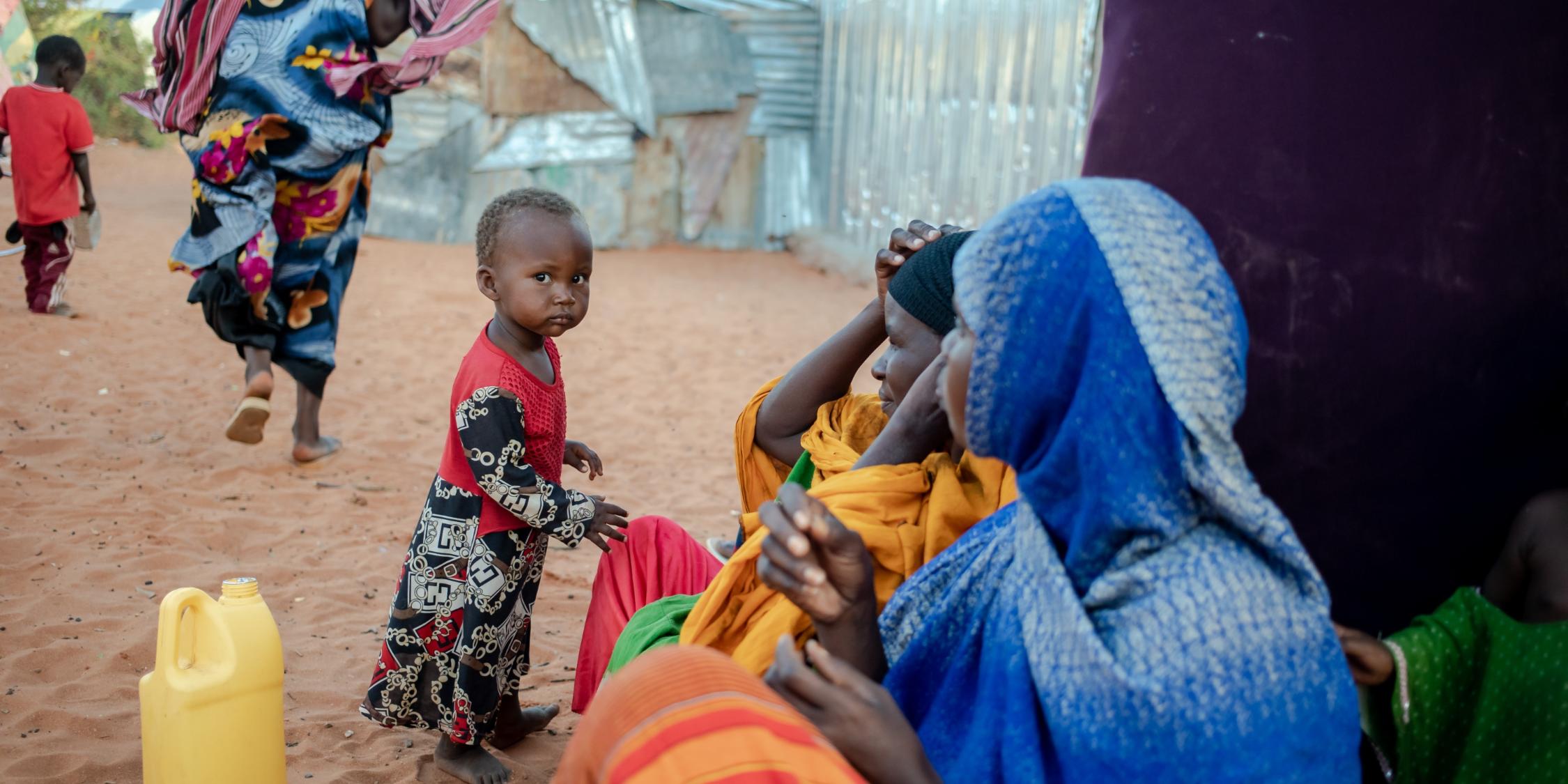 Eine Mutter sitzt mit ihrer Familie vor einer provisorischen Unterkunft in einer Siedlung für Dürreflüchtlinge in Galkayo. Als Reaktion auf die zunehmende Dürre und auf die wachsende Hungerkatastrophe in Somalia ist das oberste Ziel des Projekts der Diakonie Katastrophenhilfe, einen Beitrag zu einem verbesserten und sicheren Zugang zu Wasser und Hygiene, zur Ernährungssicherheit sowie zu anderen Grundbedarfen für besonders von der Dürre und vom Gewaltkonflikt betroffene Binnenvertriebene zu leisten.  Projektpartner: Zentrum für Frieden und Demokratie - CPD