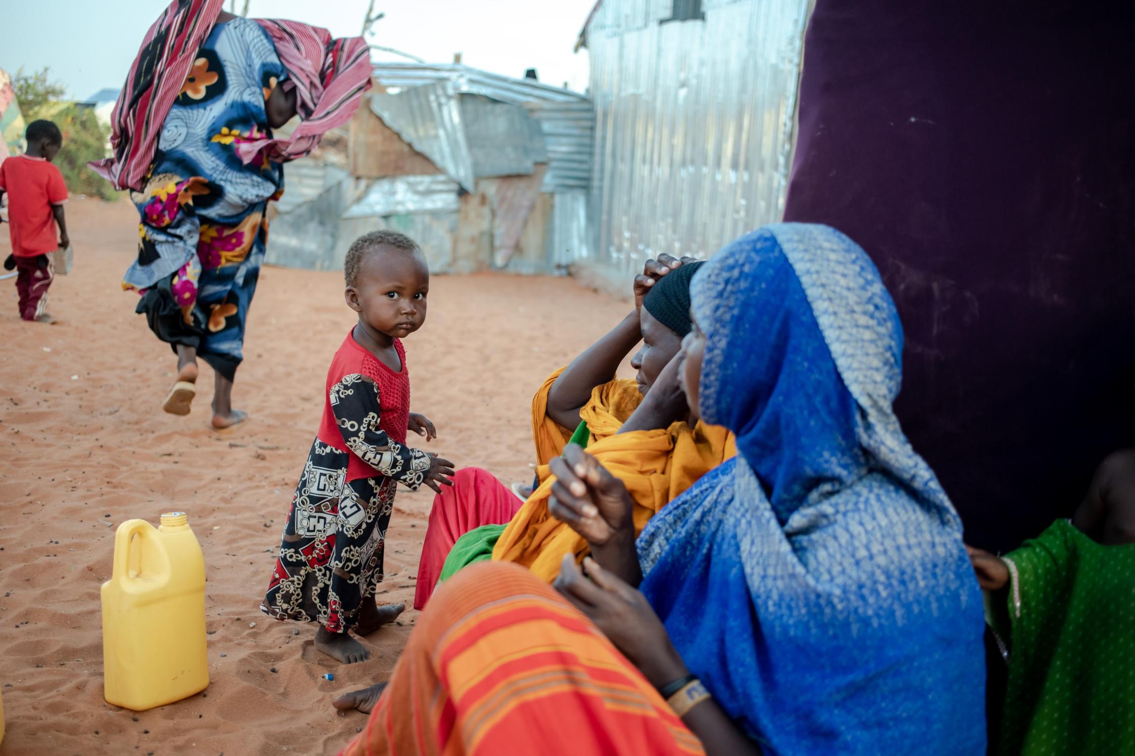Eine Mutter sitzt mit ihrer Familie vor einer provisorischen Unterkunft in einer Siedlung für Dürreflüchtlinge in Galkayo. Als Reaktion auf die zunehmende Dürre und auf die wachsende Hungerkatastrophe in Somalia ist das oberste Ziel des Projekts der Diakonie Katastrophenhilfe, einen Beitrag zu einem verbesserten und sicheren Zugang zu Wasser und Hygiene, zur Ernährungssicherheit sowie zu anderen Grundbedarfen für besonders von der Dürre und vom Gewaltkonflikt betroffene Binnenvertriebene zu leisten.  Projektpartner: Zentrum für Frieden und Demokratie - CPD