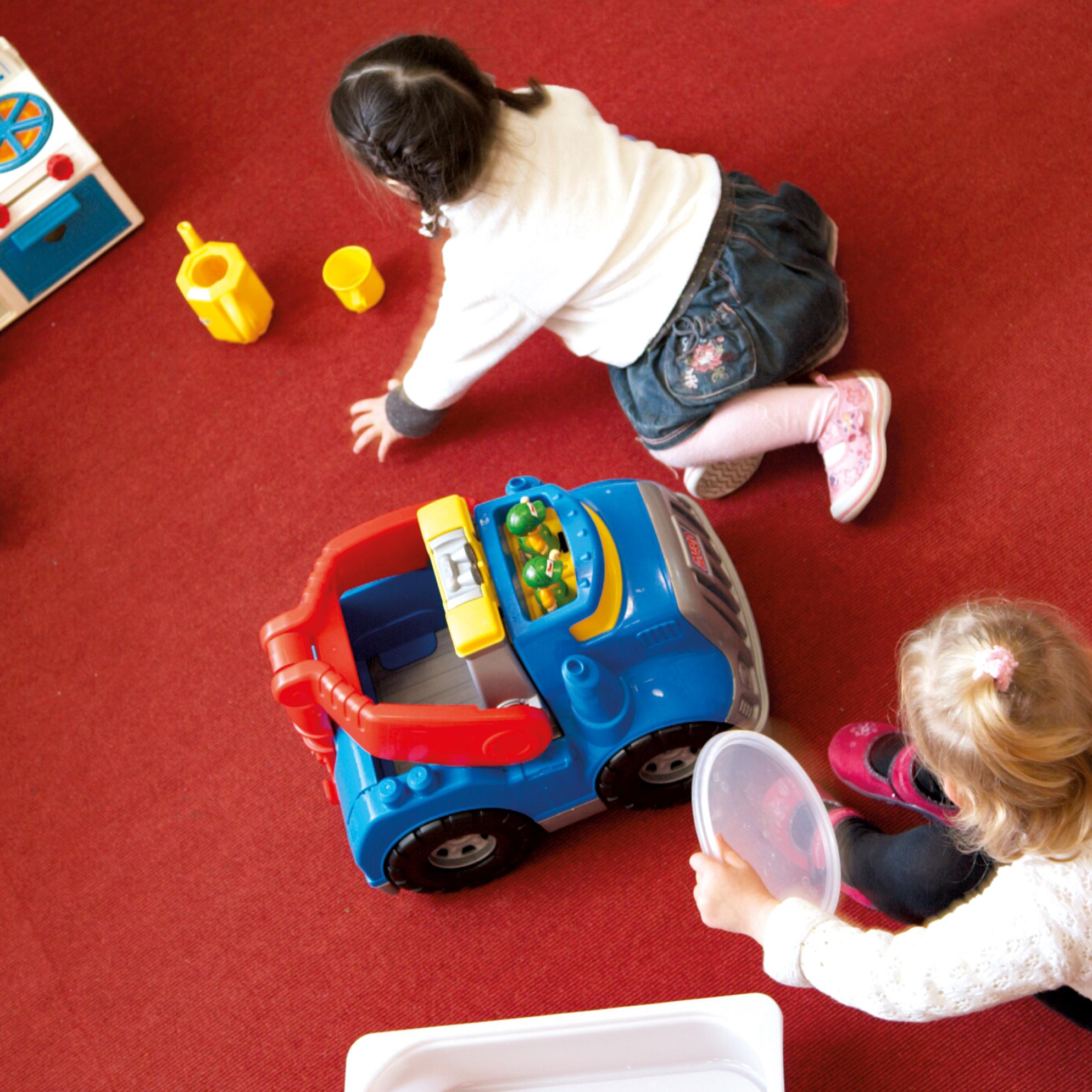 Kinder spielen auf dem Fußboden