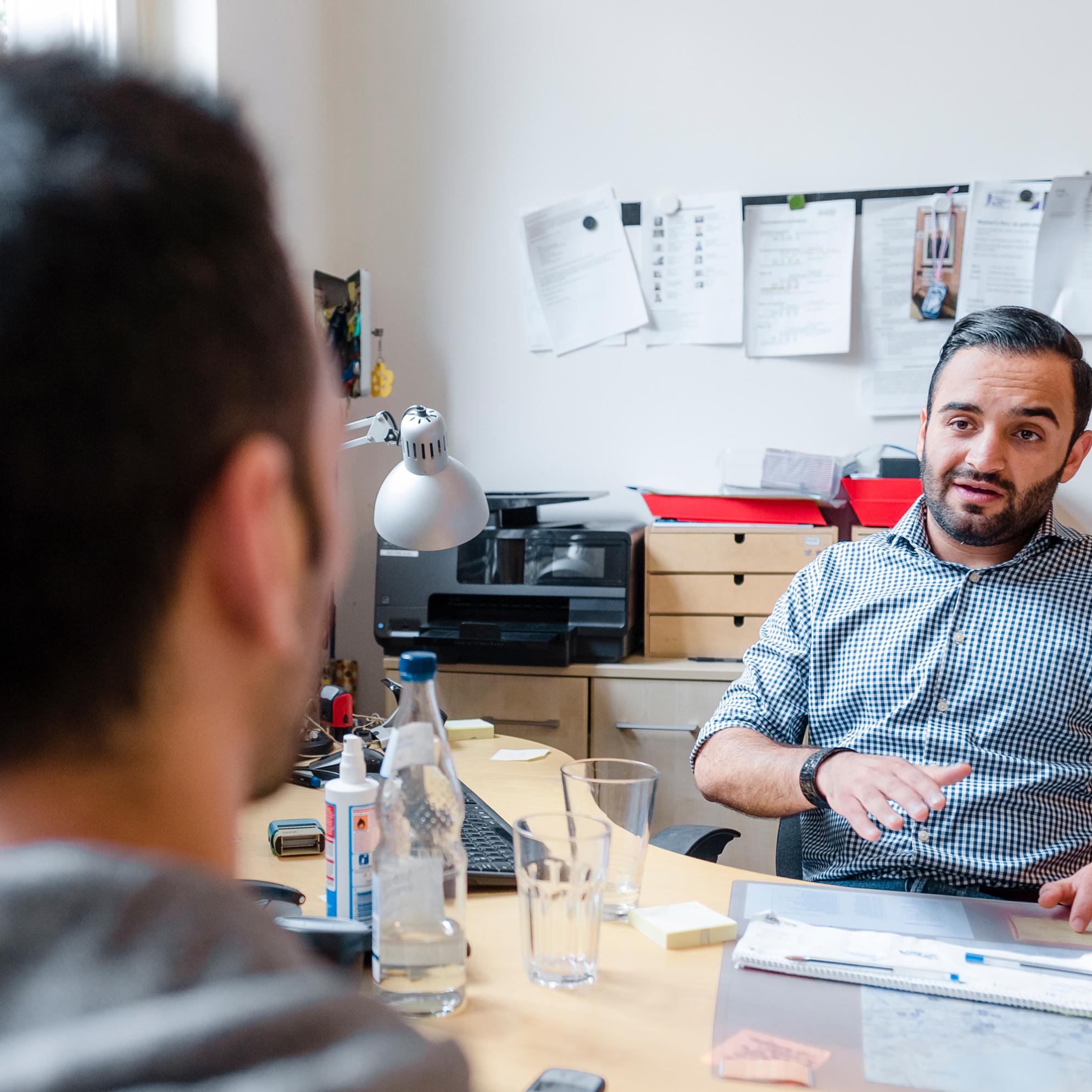 Ein Mann lässt sich von einer Fachkraft in einem Büro beraten