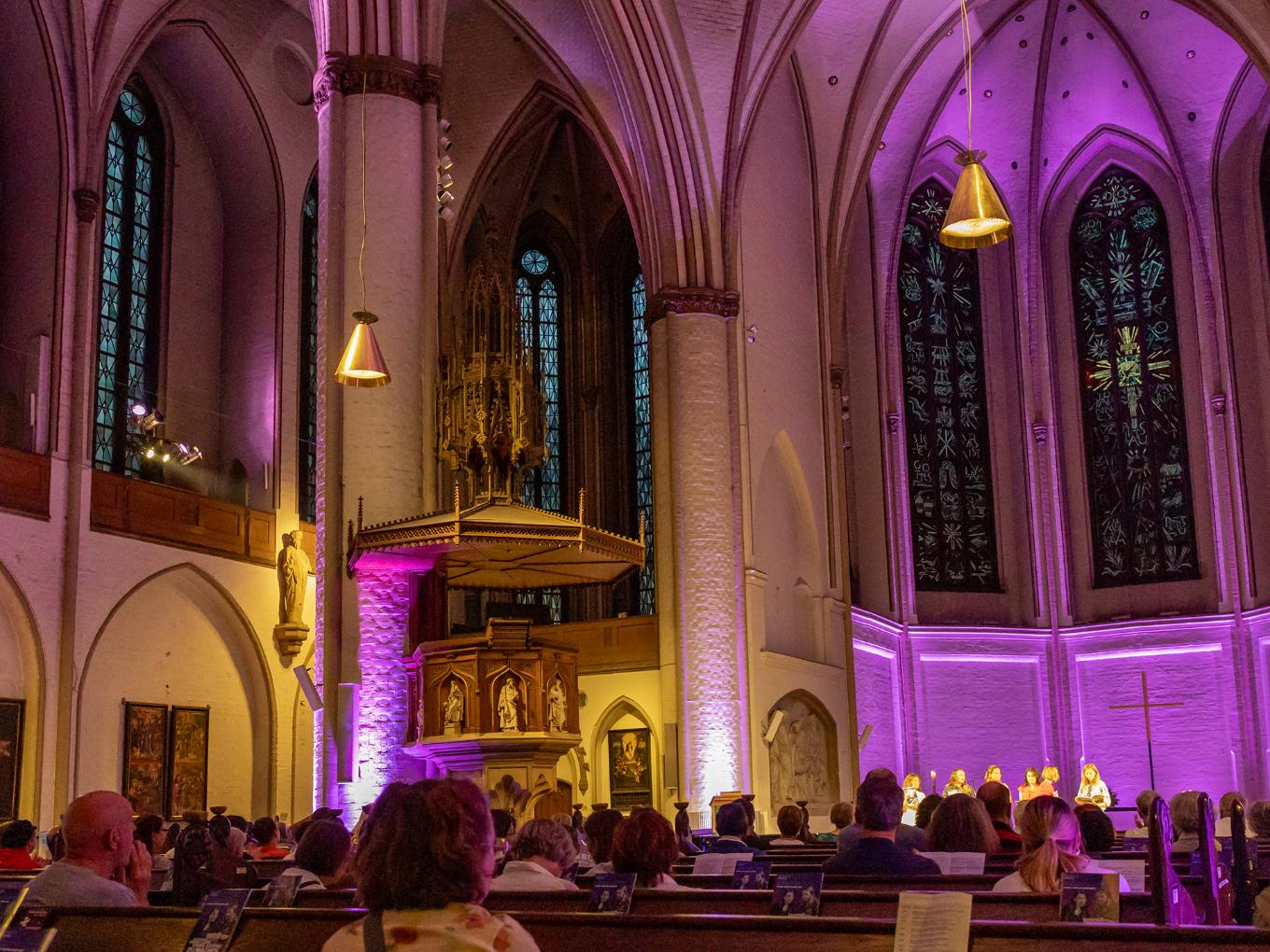 Ein Kirchensaal, der lila beleuchtet wird.