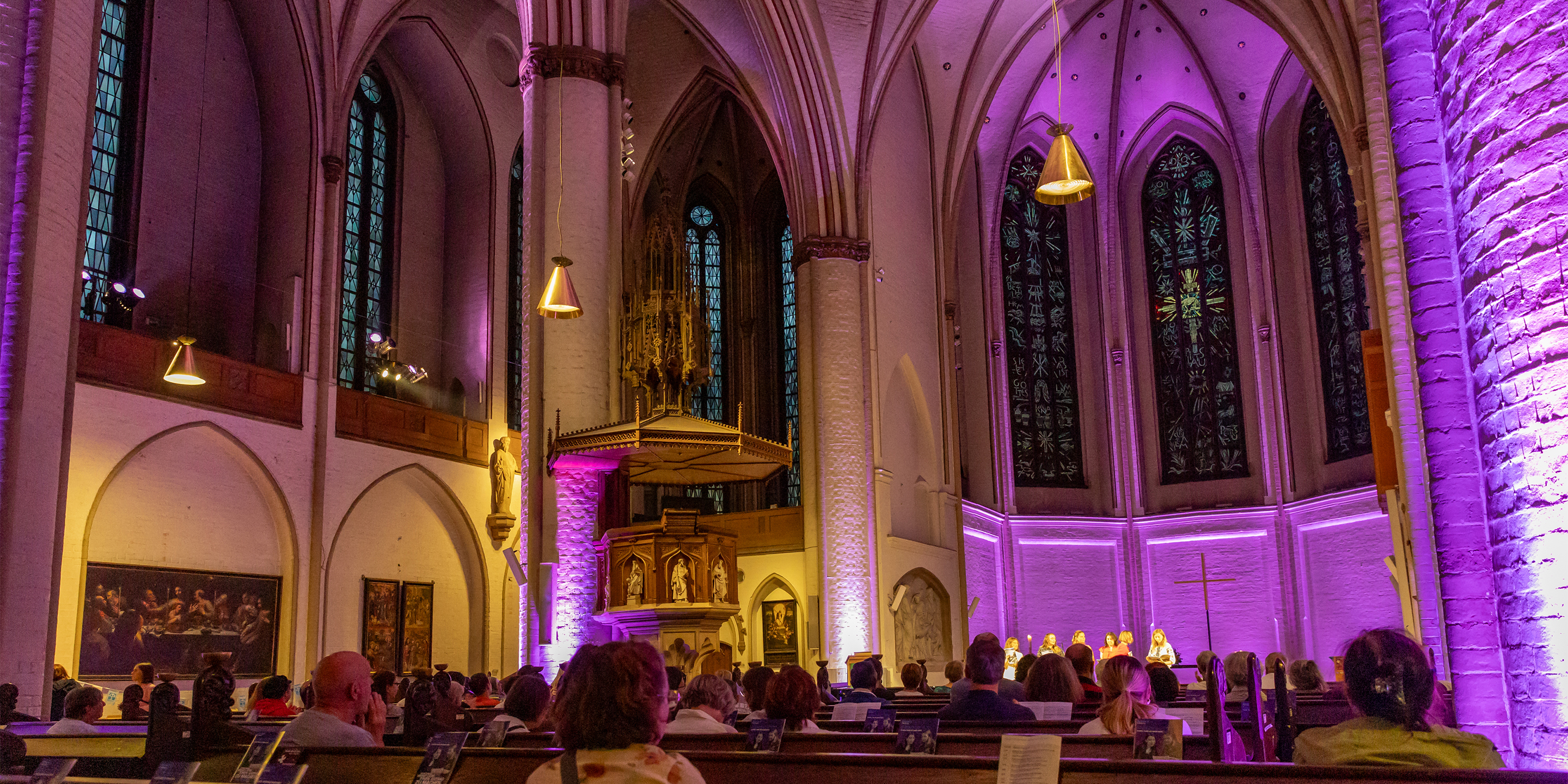 Ein Kirchensaal, der lila beleuchtet wird.