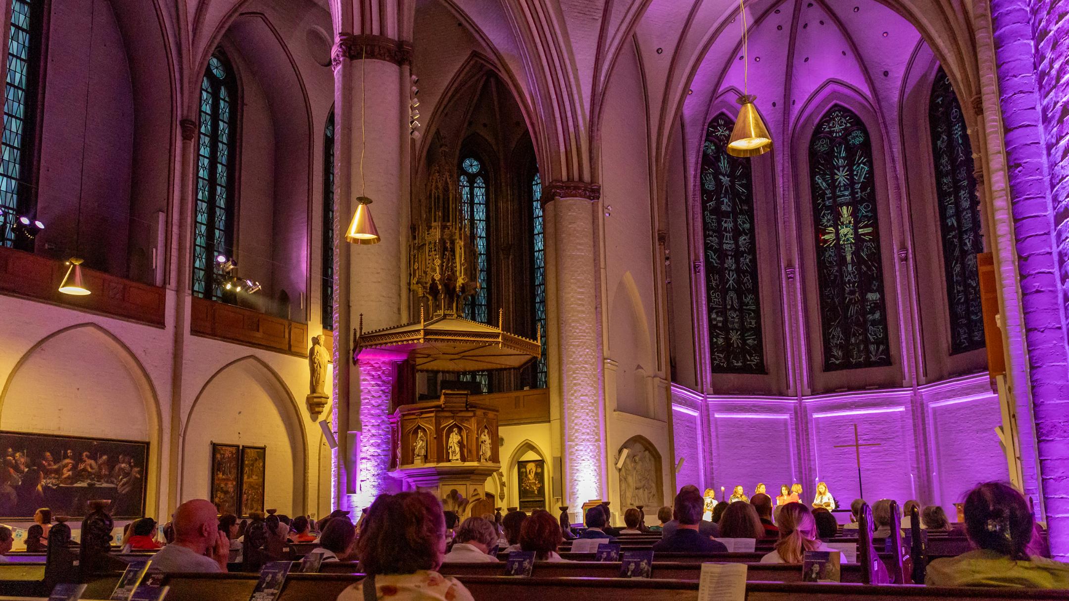 Ein Kirchensaal, der lila beleuchtet wird.