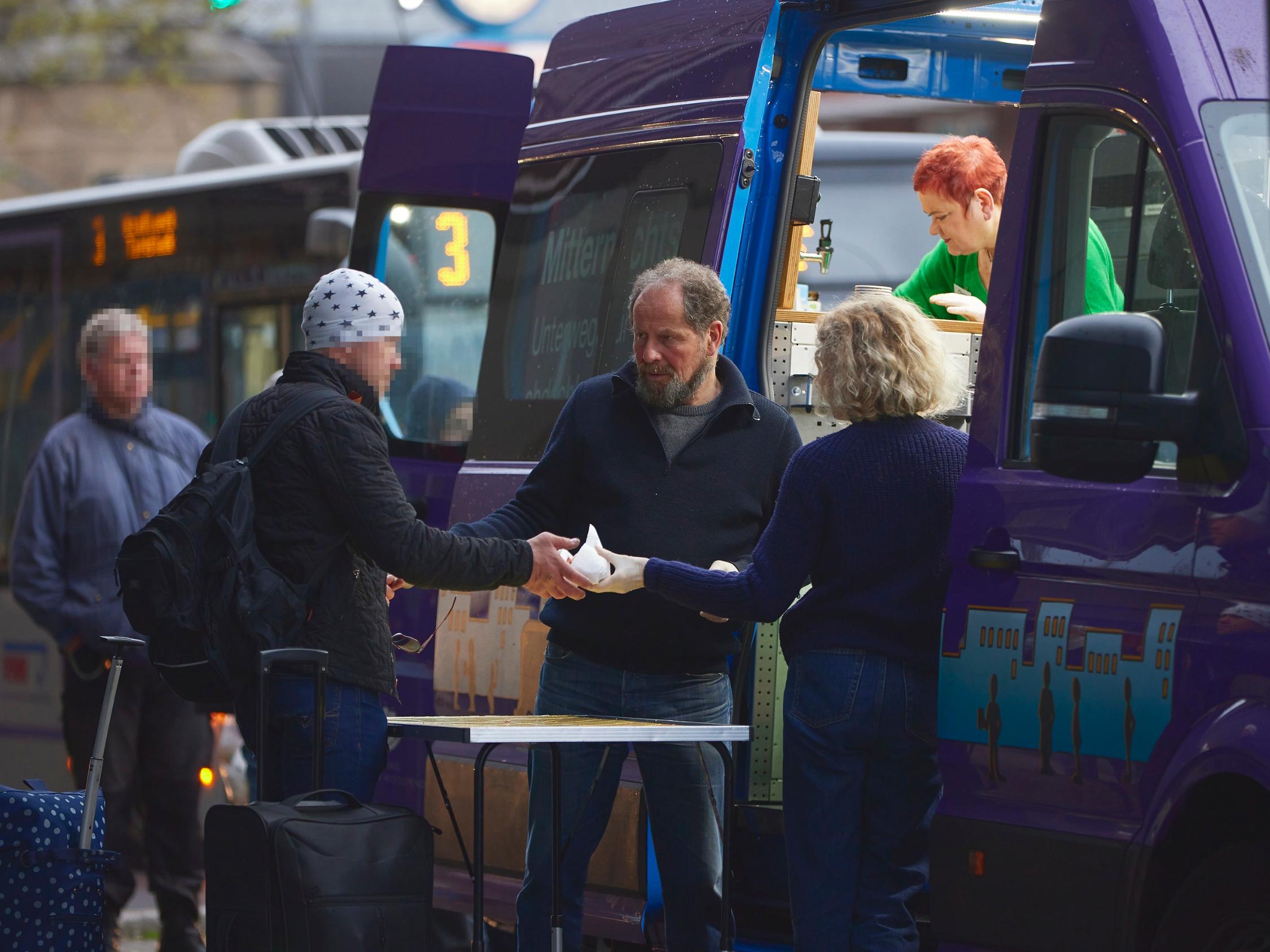 Freiwillige vom Mitternachtsbus geben Essen aus.