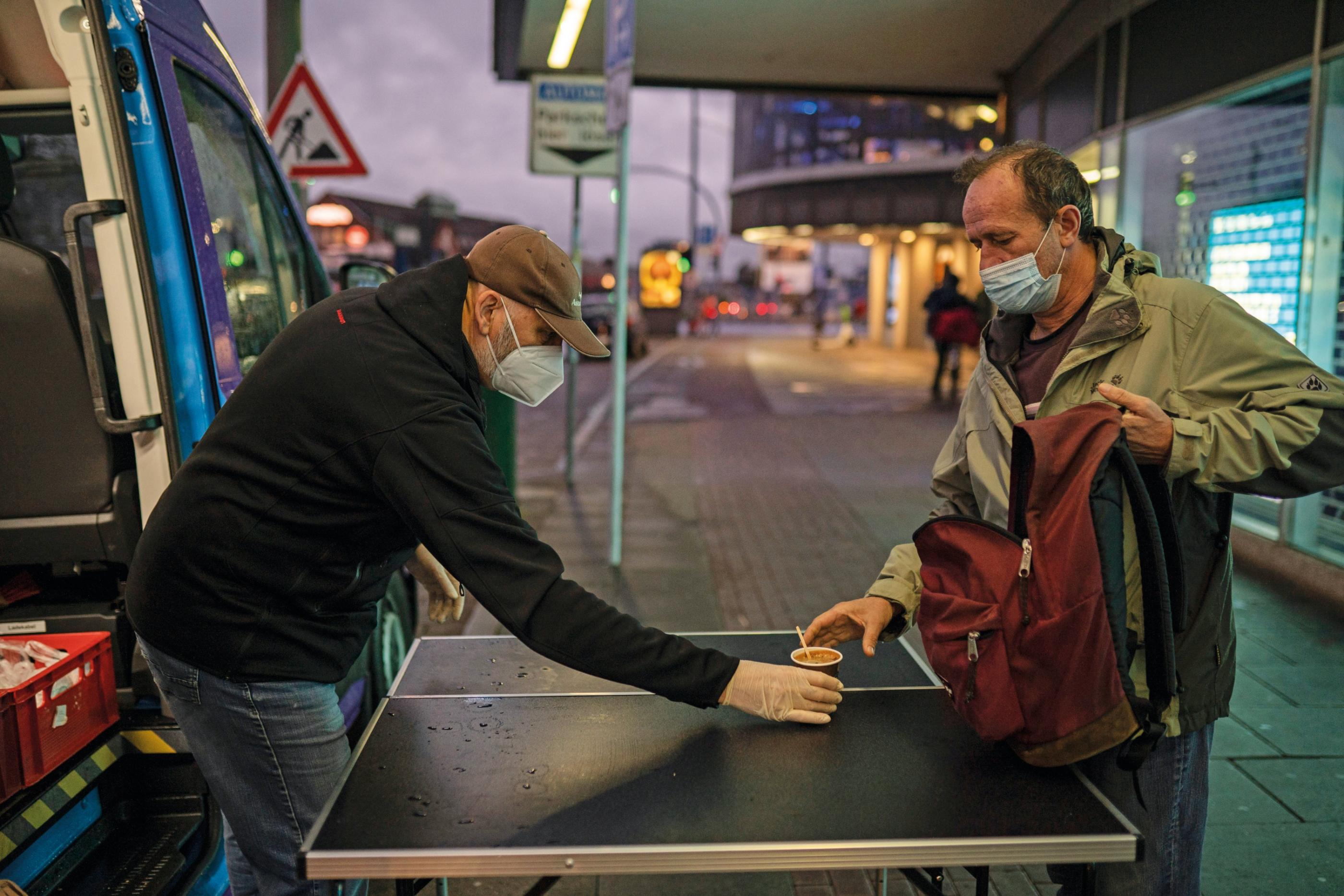 Ehrenamtliche geben Kaffee an Obdachlosen am Mitternachtsbus