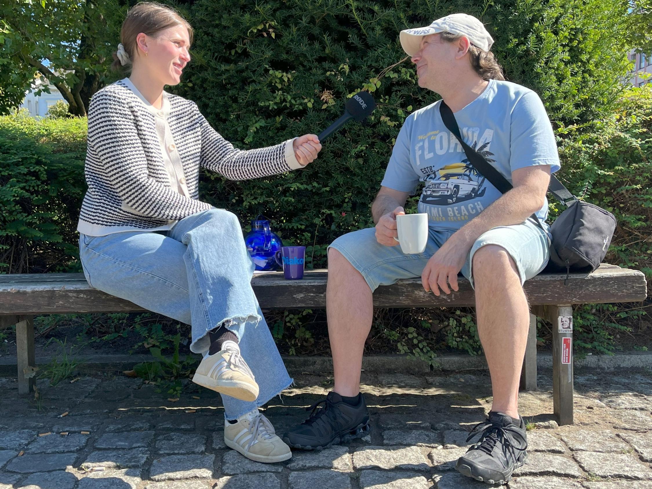 Eine Frau hält einem Mann ein Mikrofon entgegen.