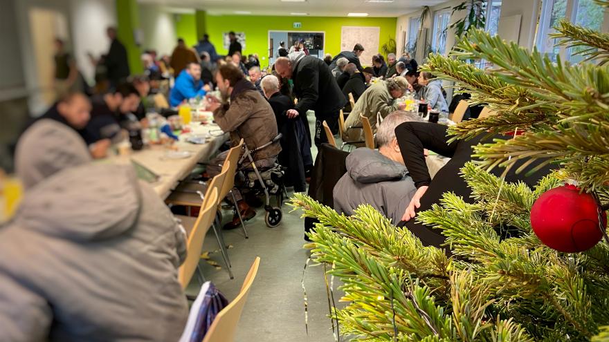 Obdachlsose sitzen beim Weihnachtsessen - Diakonie Hamburg