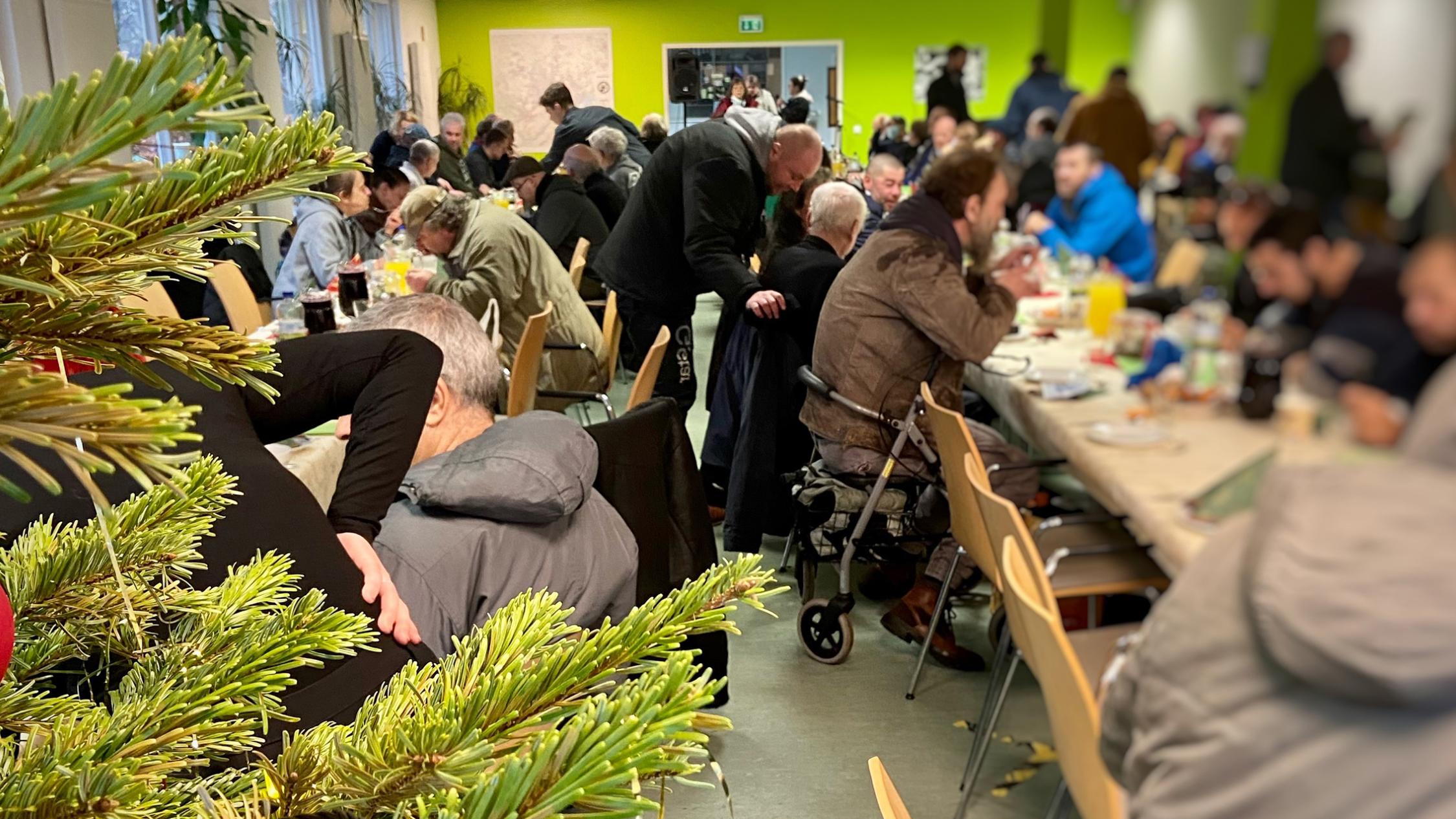 Obdachlsose sitzen beim Weihnachtsessen - Diakonie Hamburg