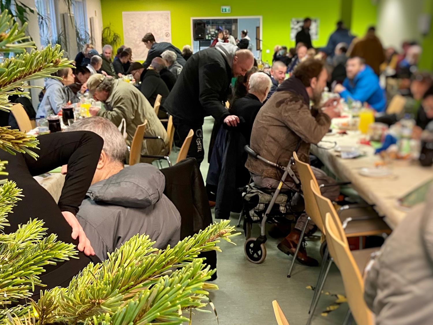 Obdachlsose sitzen beim Weihnachtsessen - Diakonie Hamburg