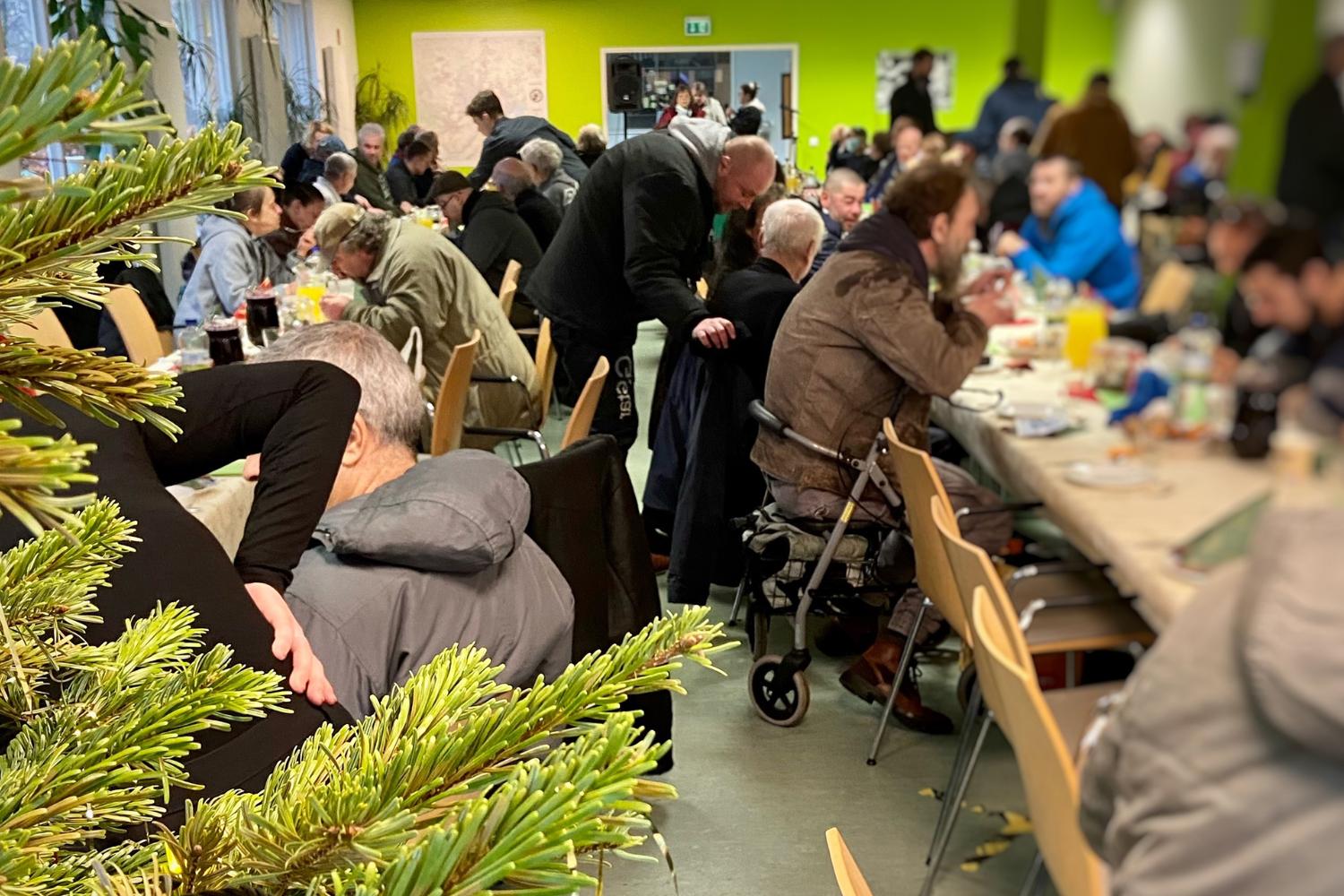 Obdachlsose sitzen beim Weihnachtsessen - Diakonie Hamburg
